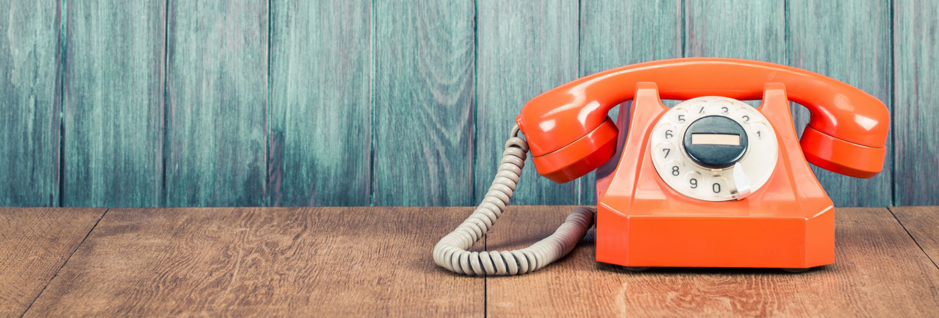 Orange Phone Against Washed Out Blue Wall 1920X650